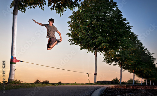 A man jumping on the slackline during sunset in Ditzingen, Germany. photo