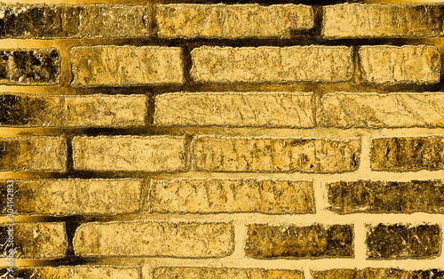 Golden background based on the image of a brick wall tinted in gold