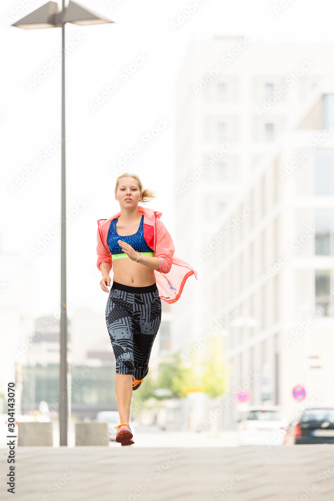 European Quarter, Stuttgart, Baden-W¸rttemberg, Germany: A female runner running through the city in the morning. European Quarter, Stuttgart, Baden-W¸rttemberg, Germany: A female runner running through the city in the morning.