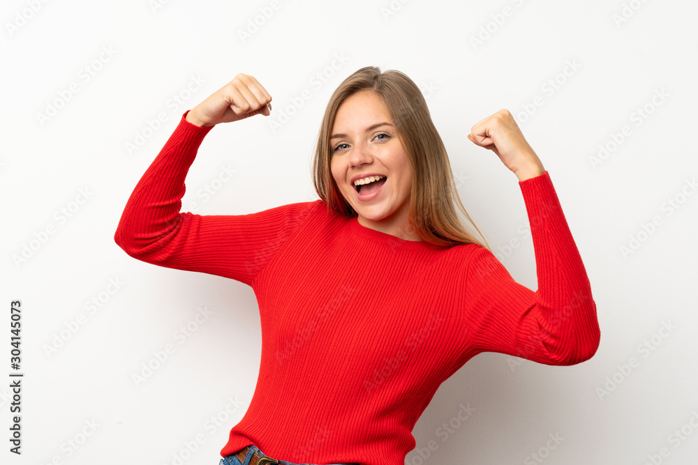 Young blonde woman with red sweater over isolated white background celebrating a victory Young blonde woman with red sweater over isolated white background celebrating a victory