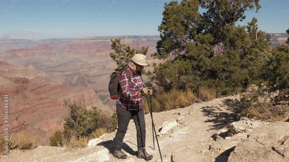 Mature Woman With A Backpack Climbs Up The Hill Rock Hiking In The Grand Canyon Mature Woman With A Backpack Climbs Up The Hill Rock Hiking In The Grand Canyon