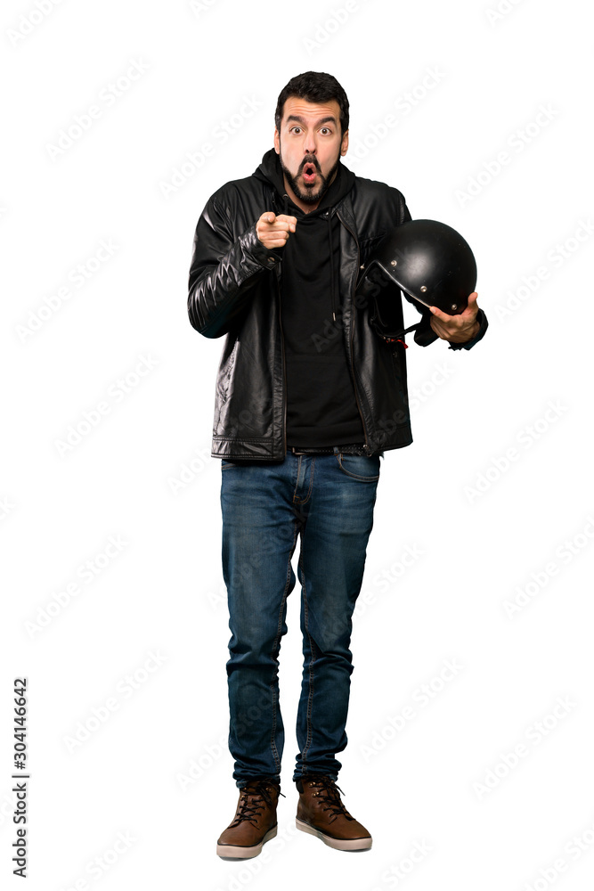 Full-length shot of Biker man surprised and pointing front over isolated white background Full-length shot of Biker man surprised and pointing front over isolated white background