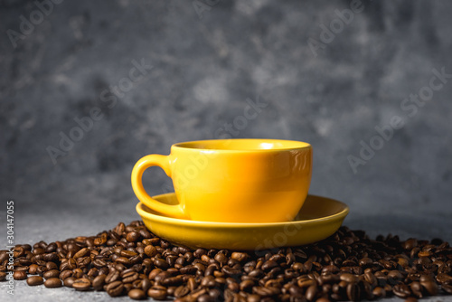 cup of coffee with beans on gray stone background