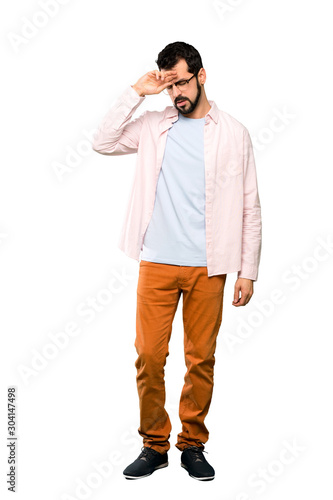 Full-length shot of Handsome man with beard with tired and sick expression over isolated white background