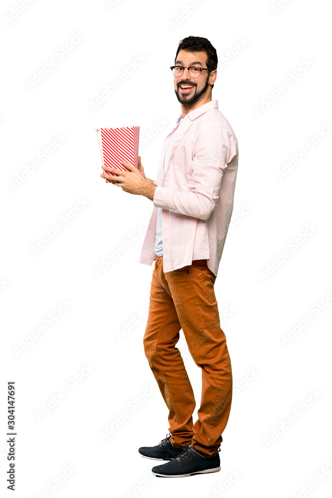 Handsome man with beard eating popcorns Handsome man with beard eating popcorns