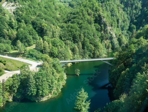 bridge suspended over a river that flows quietly through the mountains covered by woods. Centovalli train, Anzasca Valley photo