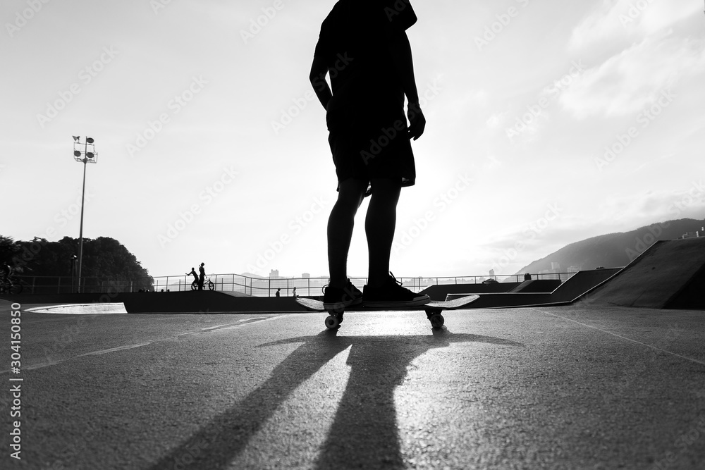 Silhouette of a skateboarder with his skateboard