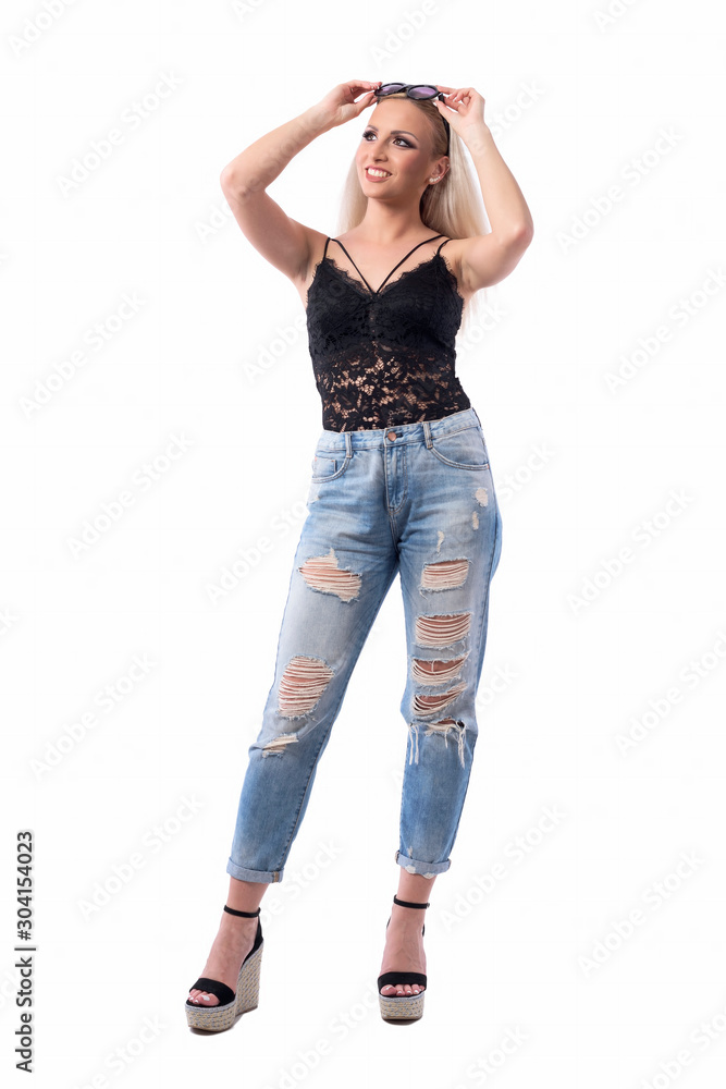 Cool modern casual style young woman with sunglasses on head looking up and smile. Full body isolated on white background. Cool modern casual style young woman with sunglasses on head looking up and smile. Full body isolated on white background.