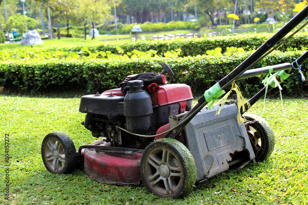 Fototapeta premium Old red lawn mower on the lawn