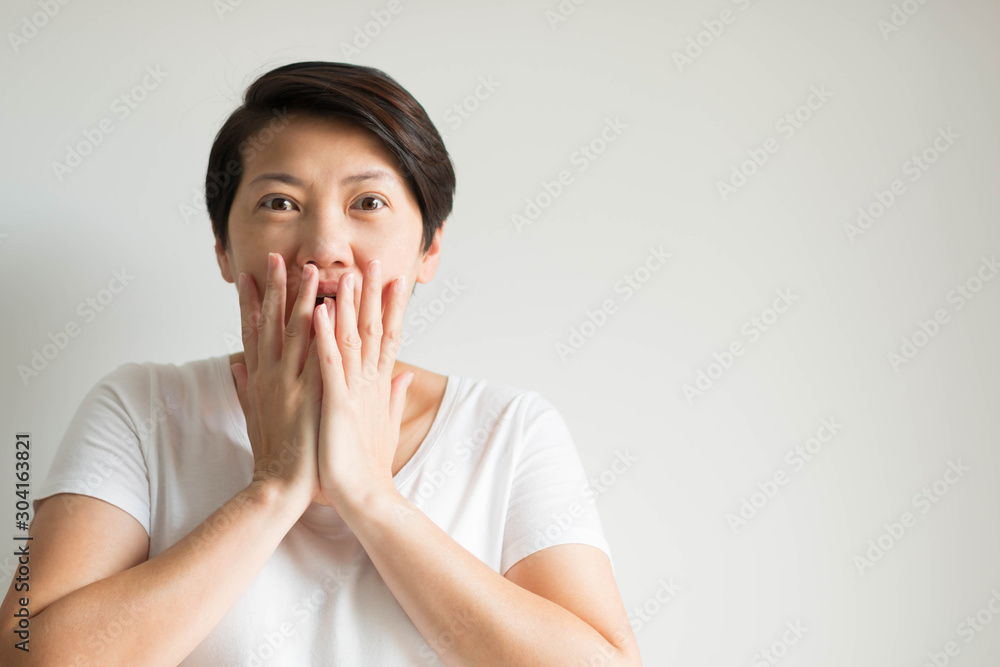 Portrait of a woman expression excited and amazed in the face; using two hands closing her mouth and eyes wide open. Portrait of a woman expression excited and amazed in the face; using two hands closing her mouth and eyes wide open.