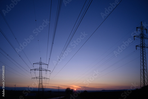 High voltage electric tower and powerlines at sunset