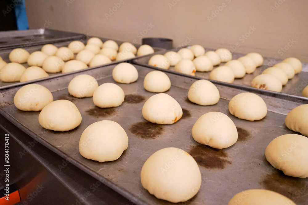 Pieces of dough buns on metallic tray before putting into oven, homemade unbaked dough bun Pieces of dough buns on metallic tray before putting into oven, homemade unbaked dough bun