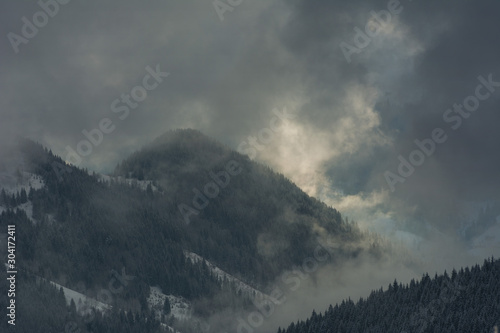Fototapeta Naklejka Na Ścianę i Meble -  Fogs and clouds in winter Ukrainian Carpathians with snow-covered trees and mountain peaks