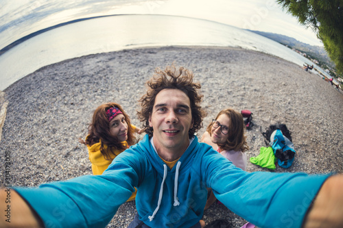 A man takes a selfie with women. photo