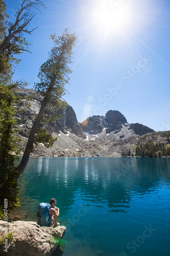 A woman rests by the beautiful Sheep Lake in the Seven Devil Mountains in Central Idaho.  He Devil sits prominantly in the background. photo