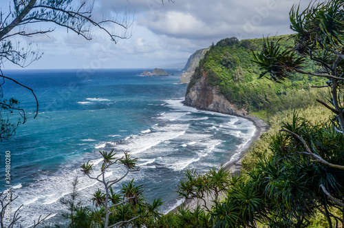 Gorgeous view overlooking waves breaking on Pololu Valley Beach (a black sand beach) below lush cliffs on a windy day, Big Island, Hawaii, USA photo