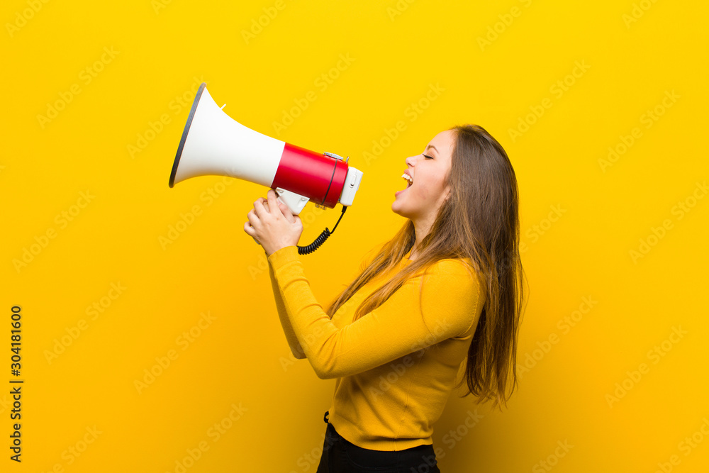 young pretty woman with a megaphone - obrazy, fototapety, plakaty 