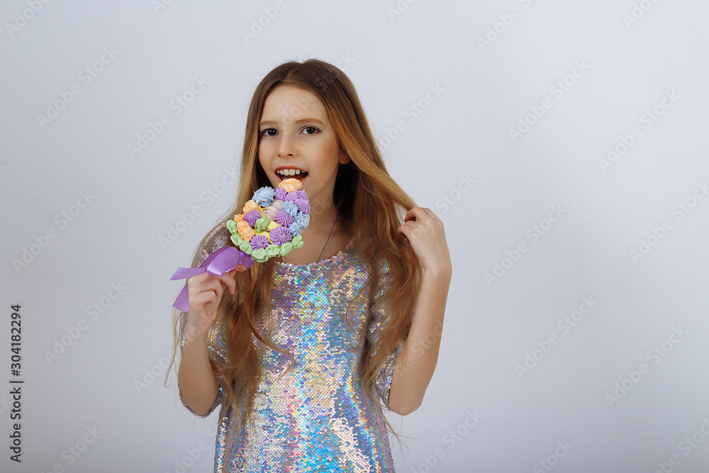 beautiful girl smiles and holds a lolly in her hands. a marshmallow long blond hair. beautiful girl smiles and holds a lolly in her hands. a marshmallow long blond hair.