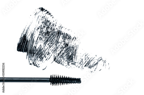 Black smear mascara and brush on white background. Trend concept. Isolated. Makeup. Cosmetic products for eyelashes. Photography. Beauty pattern. Beautiful template for design. Closeup