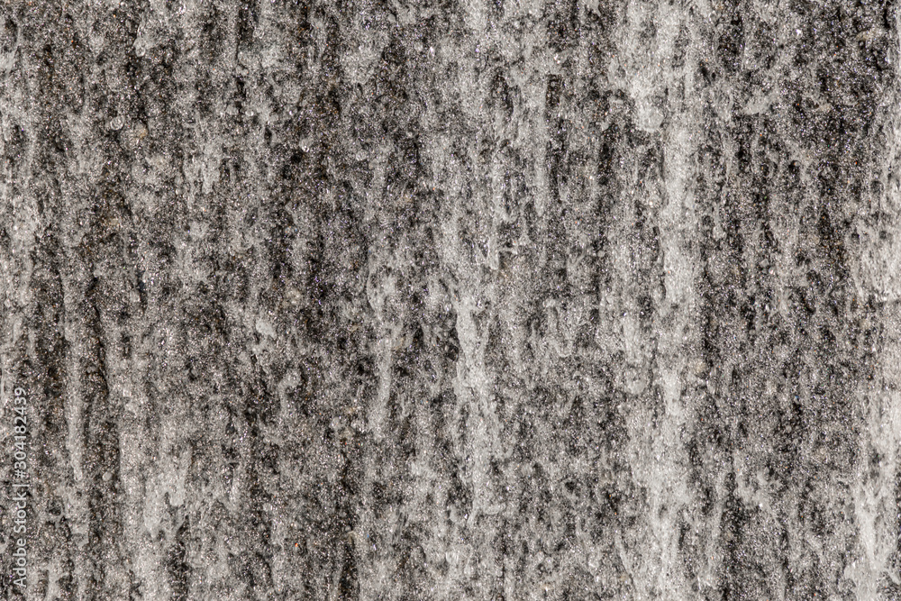 Fototapeta premium Water flowing over a rough concrete wall