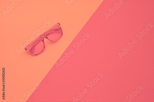 Minimal fashion, Trendy sunglasses. Party vibration on pink geometry background. Hipster accessory Flat lay. Art creative summer vibes fashionable style. Design vibrant color, gel filter. Top view