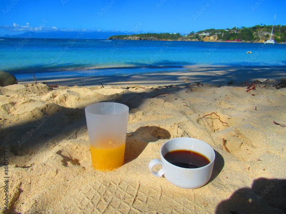 Café et jus de fruit pour un petit déjeuner à la plage face à la mer Café et jus de fruit pour un petit déjeuner à la plage face à la mer