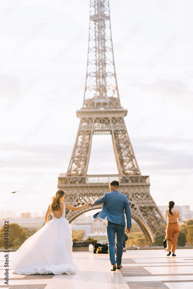 Happy romantic married couple hugging near the Eiffel tower in Paris