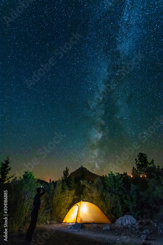 starry night with the Milky Way on the Turkish Mediterranean coast amidst the rocky mountains with tourists in a yellow tent