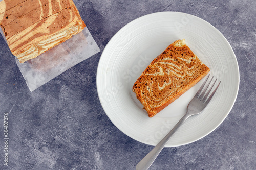 Slices of Marble Cake on a Plate and the Table, Directly Above Photo on Dark Background.