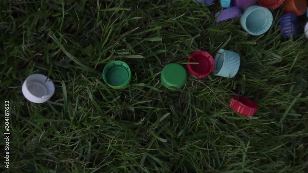 Plastic bottle caps are on the lawn Plastic bottle caps are on the lawn