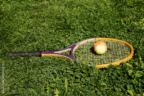 Tennis Racket With Ball On Grass