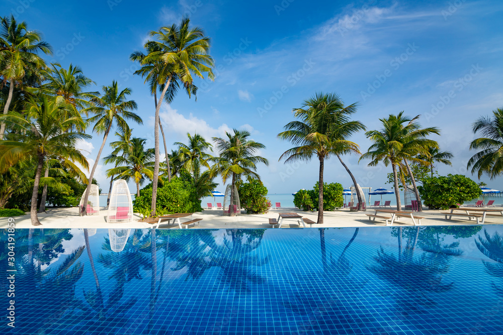 Beautiful beach and pool. View of nice tropical beach with palms around. Holiday and vacation concept. Tropical beach. Beautiful beach and pool. View of nice tropical beach with palms around. Holiday and vacation concept. Tropical beach.