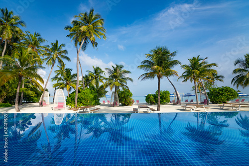 Beautiful beach and pool. View of nice tropical beach with palms around. Holiday and vacation concept. Tropical beach.