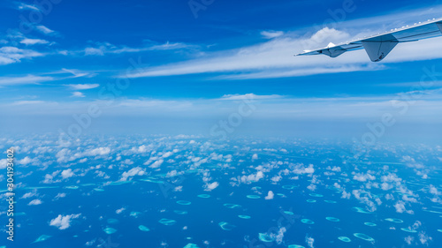 Aircraft wing flying over the blue clouds.