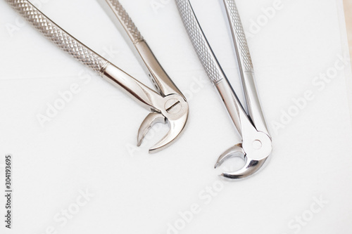 Canvastavla Dental forceps for removing teeth on a white isolated background.
