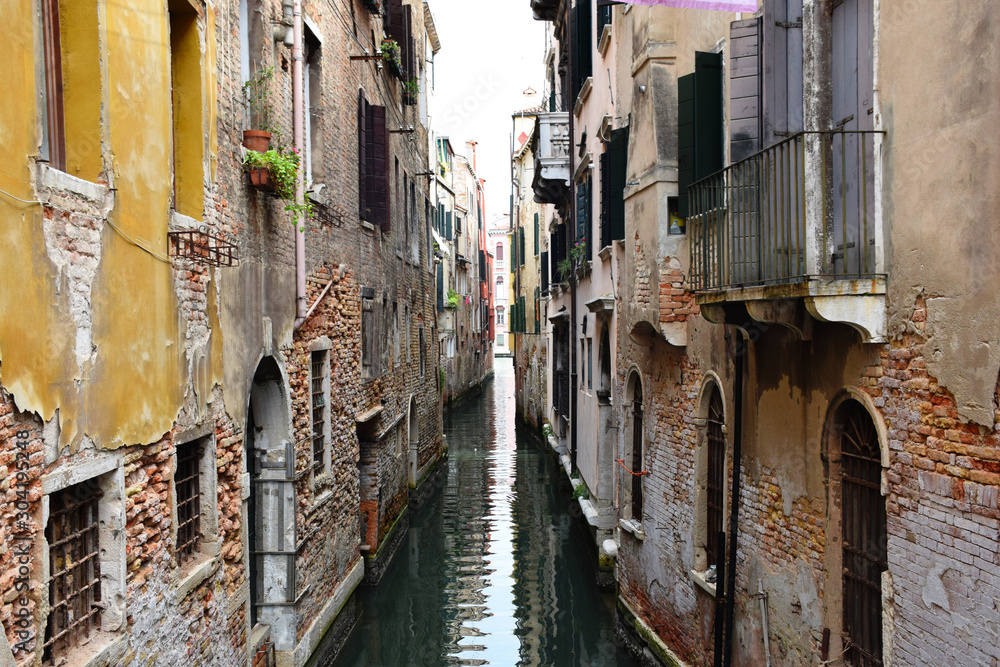 Narrow Water Canal Between Residential Houses in a Quiet Area of Venice, Italy