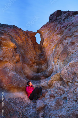 A woman enjoys the view of the iconic arch along the Arch Trail (1/2 mile roundtrip) in the Clarno Unit  the John Day Fossil Bed National Monument. photo