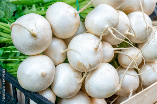 Freshly harvest white radish on a market stall.