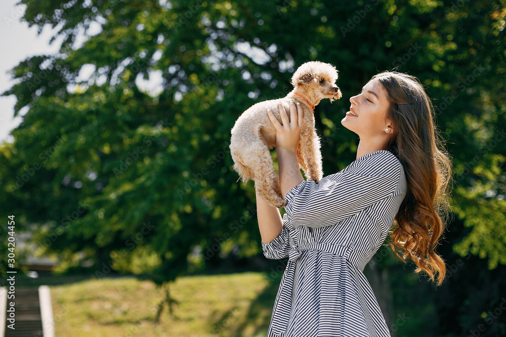 Beautiful girl in a blue dress. Woman in a summer park. Lady with a dog Beautiful girl in a blue dress. Woman in a summer park. Lady with a dog