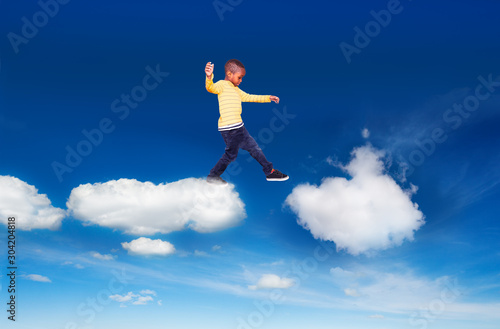 Little boy walking from one cloud to another