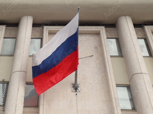 Quadro em tela The national flag of the Russian Federation is attached to the wall of the build