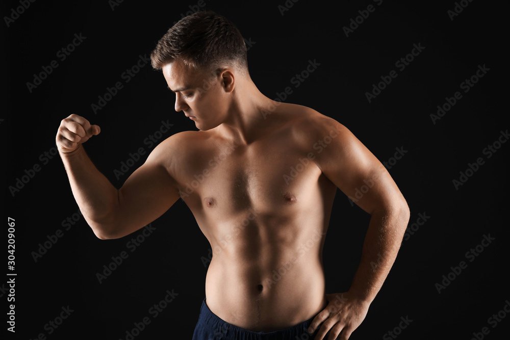 Handsome male bodybuilder on dark background