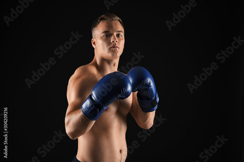 Sporty male boxer on dark background © Pixel-Shot