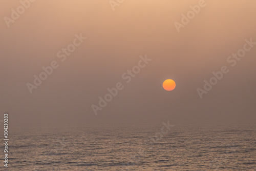 Foggy sunrise in the summer sea shore