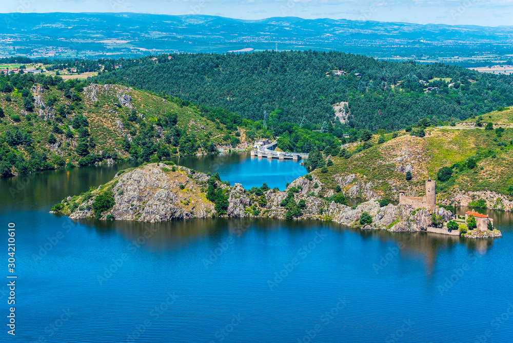 Grangent island in the Gorges de la Loire with old castle ruins at right. Grangent hydroelectric dam is at background.