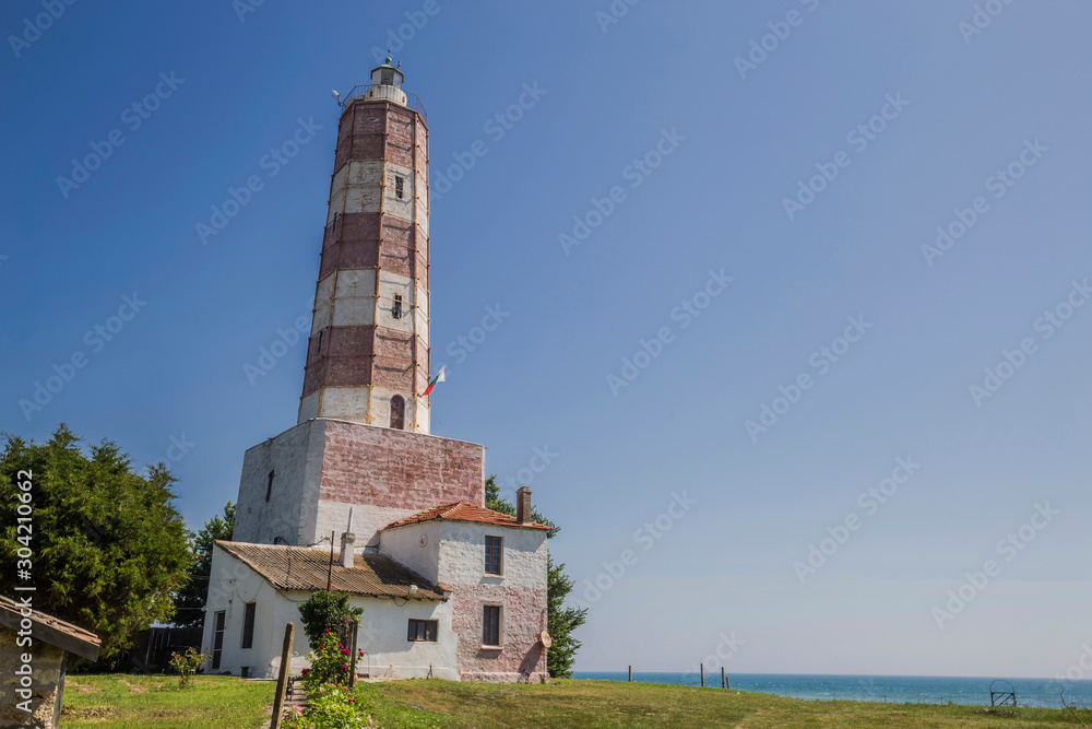 Lighthouse on sea shore in sun light