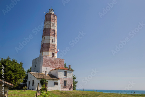 Lighthouse on sea shore in sun light