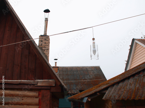 Photo of rural life in the Belarusian Outback. an old moss covered roof and brick chimneys