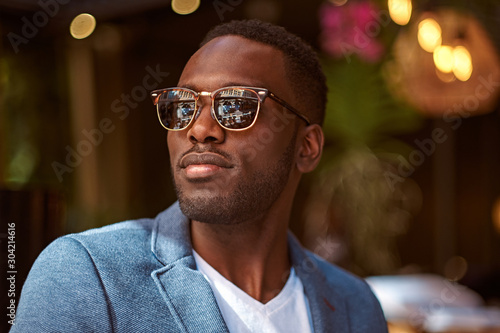 Portrait of young confident american businessman in sunglasses and blue blazer.
