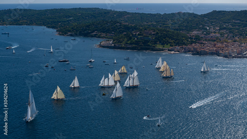 French Riviera - modern and old sail race above aerial view in St -Tropez gulf with Saint tropez village in background